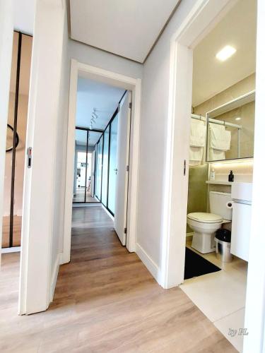 a bathroom with a toilet and a hallway at Xingu Reserva Ipanema in Porto Alegre