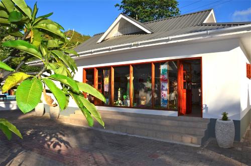 a building with a store front with glass windows at Britannia Hotel in Grand'Anse Praslin