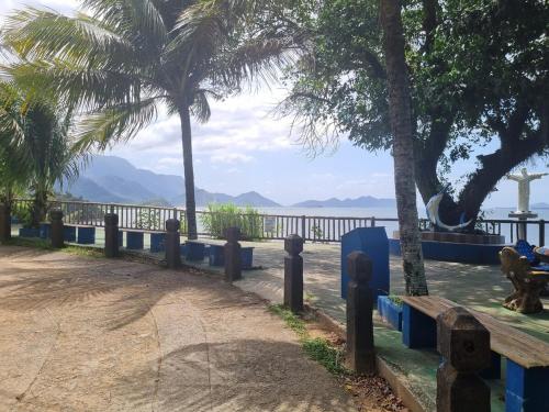 a park with palm trees and a view of the water at Casa em Mangaratiba RJ - 40 metros da Praia in Mangaratiba