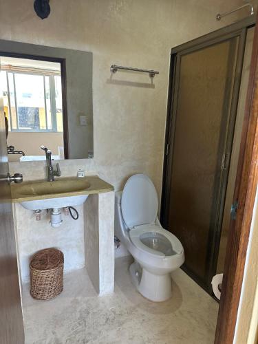 ein Badezimmer mit Toilette und Waschbecken in der Unterkunft Puul Suites in Mérida