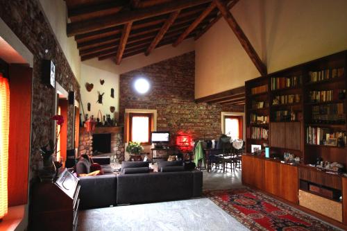 sala de estar con sofá negro y pared de ladrillo en Agriturismo Helianthus, en Oleggio