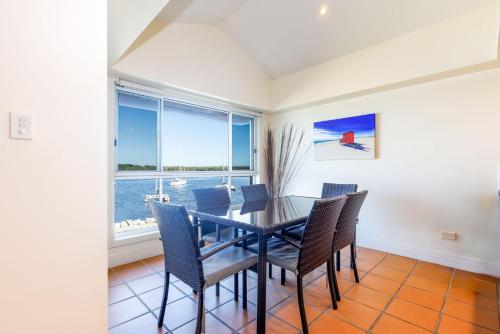 a dining room with a table and chairs and a window at Riverview Apartment 2.6 3-5 Riverview Street in Iluka