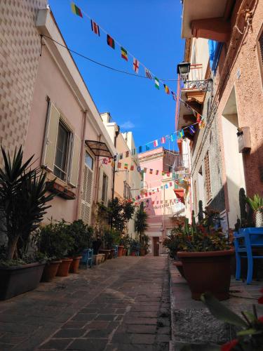 an alley with flags and potted plants and buildings at Casa Polixeni - Da e Nònne in Carloforte