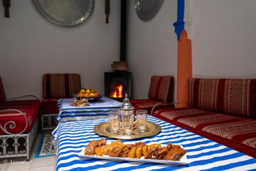 a room with two tables with food and a fireplace at Riad Alia Suites SPA in Chefchaouene