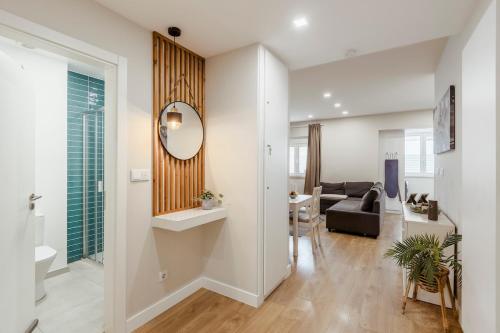 a living room with a couch and a mirror at 2-bedroom gem Central Odivelas in Odivelas