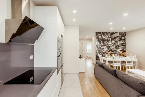 a kitchen and living room with a couch and a table at 2-bedroom gem Central Odivelas in Odivelas