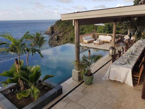 a house with a swimming pool with a view of the ocean at House of Rogues in Tortola Island