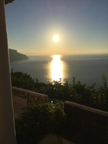 a view of the ocean with the sun setting over the water at b&b I Limoni in Ravello