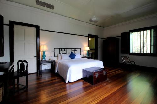 a bedroom with a white bed and a wooden floor at Cheong Fatt Tze - The Blue Mansion in George Town