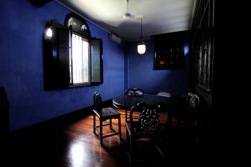 a dark blue room with a table and chairs at Cheong Fatt Tze - The Blue Mansion in George Town