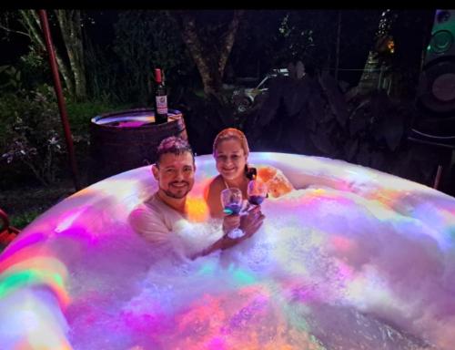 a man and a woman in a bubble bathtub covered in colors at Glamping eco descanso la vega Nocaima in Nocaima