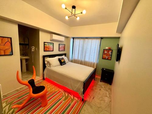 una camera con un letto e una sedia su un tappeto di Condado Terrace Apartment by the beach a San Juan