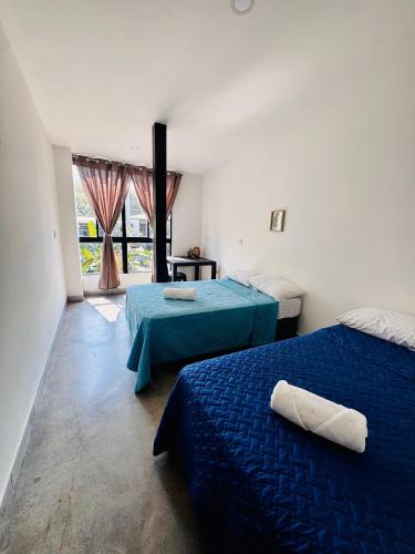 a room with two beds and a window at Vibes Wellness House in Tamanique