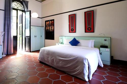 a bedroom with a white bed and some pictures on the wall at Cheong Fatt Tze - The Blue Mansion in George Town