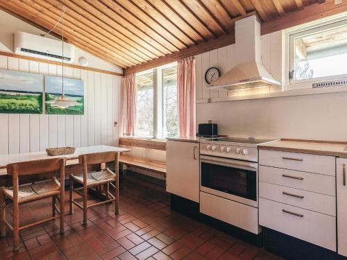 a kitchen with a table and a stove top oven at Holiday home on a holiday park in Gilleleje in Gilleleje