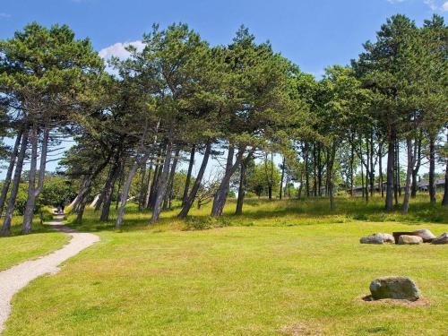 a path in a field with trees and grass at Holiday home on a holiday park in Gilleleje in Gilleleje
