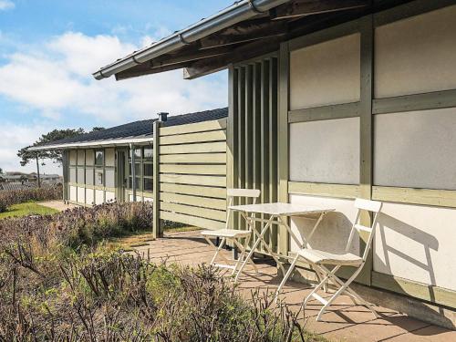 two chairs and a table on a patio next to a building at Holiday home on a holiday park in Gilleleje in Gilleleje
