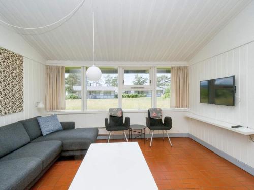 a living room with a couch and a table at Holiday home on a holiday park in Gilleleje in Gilleleje