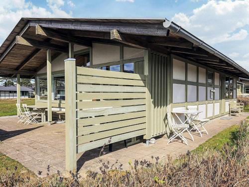 a building with a table and chairs in front of it at Holiday home on a holiday park in Gilleleje in Gilleleje