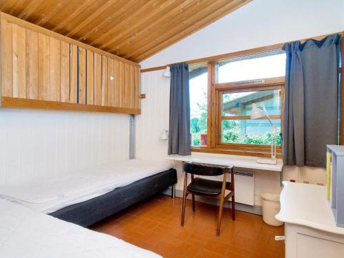 a room with a bed and a desk and a window at Holiday home on a holiday park in Gilleleje in Gilleleje