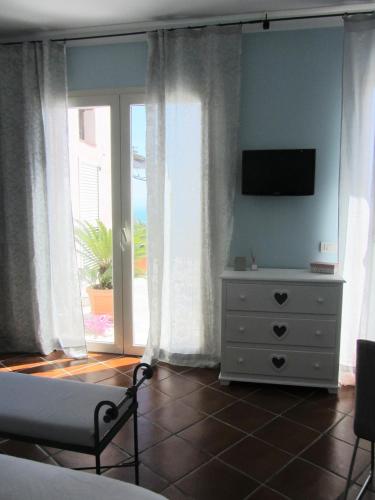 a bedroom with a bed and a dresser with a television at b&b I Limoni in Ravello