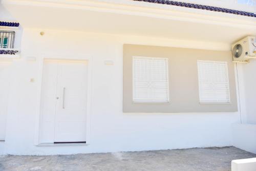 a white room with two doors and two windows at Beau séjour in Bin Rhilouf