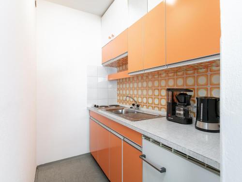 a kitchen with orange and white cabinets at Brixen Alpin Living Top 7 in Brixen im Thale