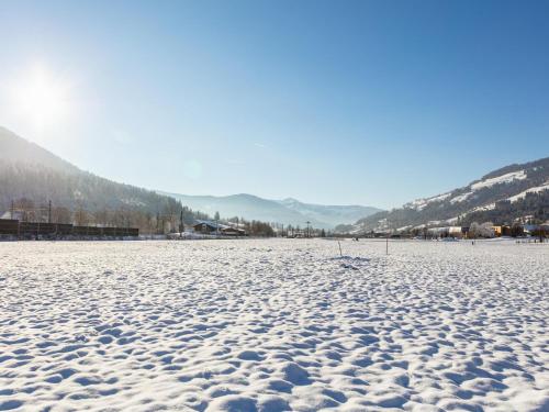 a snow covered field with mountains in the background at Brixen Alpin Living Top 7 in Brixen im Thale