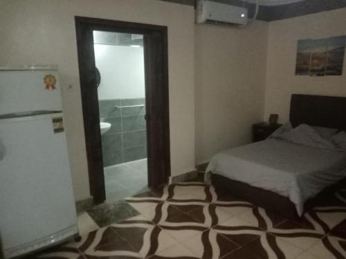 a bedroom with a bed and a bathroom with a shower at PYRAMIDS Villa T Medetion Camping in Banī Ghālib