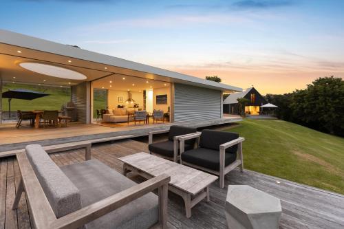 an outdoor deck with furniture and a house at Number 29 in Oneroa