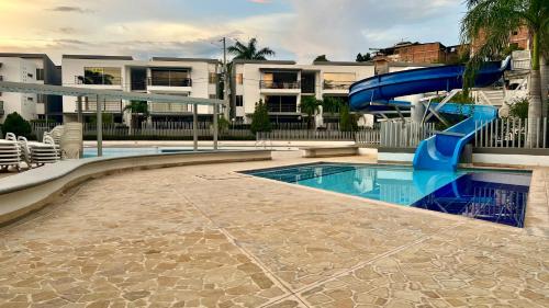a swimming pool with a slide in a apartment at Hermoso Apartasol!! cerca a Plaza Principal, Aire Acondicionado, Vista a la Piscina in Santa Fe de Antioquia