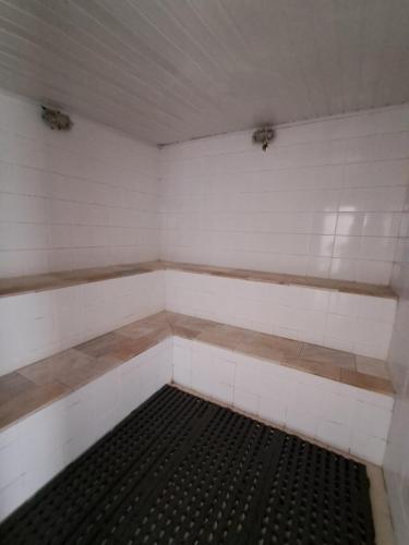 an empty room with white walls and a black grate at Apartamento Golden Beach Guarujá in Guarujá