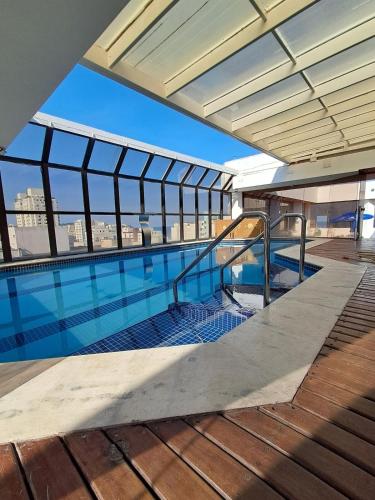 a swimming pool on the top of a building at Apartamento Golden Beach Guarujá in Guarujá