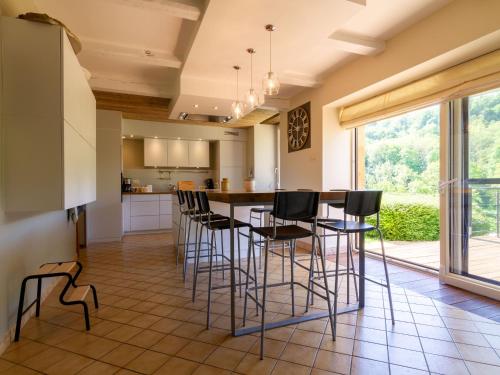 une cuisine avec un bar et des tabourets dans l'établissement Maison de charme à la campagne avec terrasse et grand espace extérieur - FR-1-585-76, à Bazeilles-sur-Othain