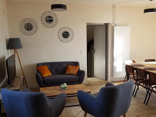 un salon avec un canapé, une table et des chaises dans l'établissement Presbytère écorénové avec terrasse et vue sur étang, proche Parc Naturel Régional de la Brenne - FR-1-591-180, à Lingé