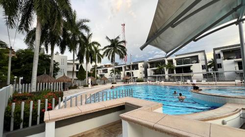a large swimming pool with people in the water at Hermoso Apartasol!! cerca a Plaza Principal, Aire Acondicionado, Vista a la Piscina in Santa Fe de Antioquia