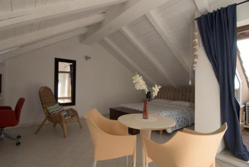 a bedroom with a bed and a table and chairs at Residenza D'epoca 1861 in Santa Maria di Castellabate
