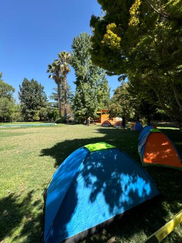 a blue tent and two tents in a field at Vista Luna Lodge con tinaja caliente in Lampa