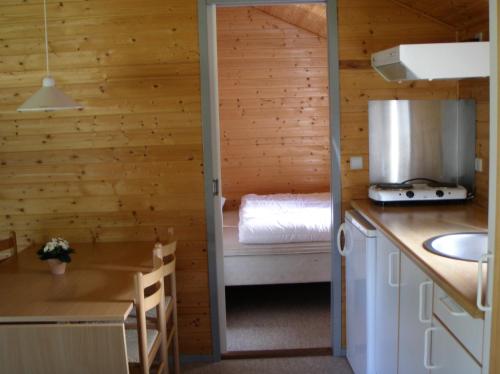a room with a kitchen and a bed in a cabin at Vejle City Camping in Vejle