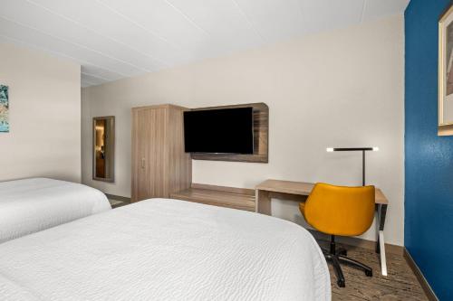 a hotel room with a bed and a desk and a television at Holiday Inn Express Boston North-Woburn by IHG in Woburn