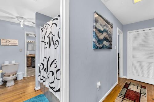 a white hallway with a toilet and a painting on the wall at The House on the Hill - Year Round Rental in Augusta