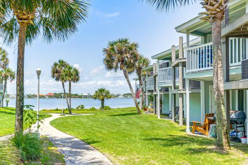 a walkway between two houses with palm trees at Sea La Vie Condo Pensacola Beach Access! in Pensacola Beach