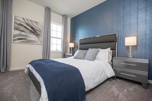a bedroom with a large bed with a blue wall at Stylish 5-Bedroom Villa - Perfect Disney Getaway! in Davenport