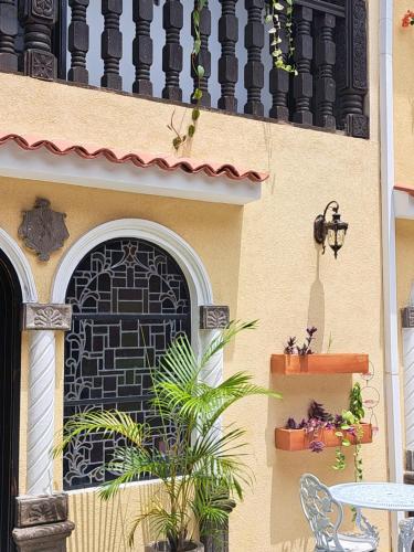 a building with a black door and a table and a plant at Casa Sileo - boutique Hotel in Cali