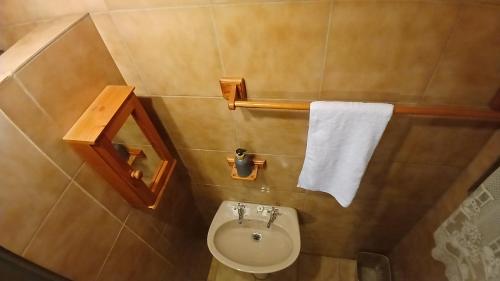 a bathroom with a toilet and a white towel at Canimambo at The Old Post Office Inn in Graskop