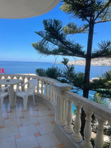 a balcony with a table and chairs and the ocean at Apartments Romario in Sarandë