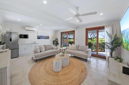 a living room with two couches and a table at The Pacific - Absolute Beachfront in Buddina in Buddina