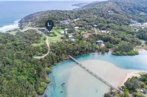 an aerial view of a bridge over a body of water at Korogoro Beach House in Hat Head