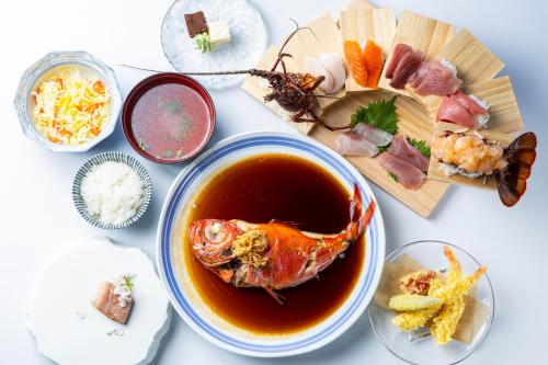 a table with a bowl of soup and a plate of food at Ocean View Hiromi SPA Hotel温泉と絶景の宿 in Shimoda
