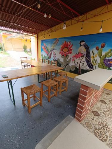 a dining room with a table and chairs and a mural at Casa Alojamiento Tocllaraju in Tarica